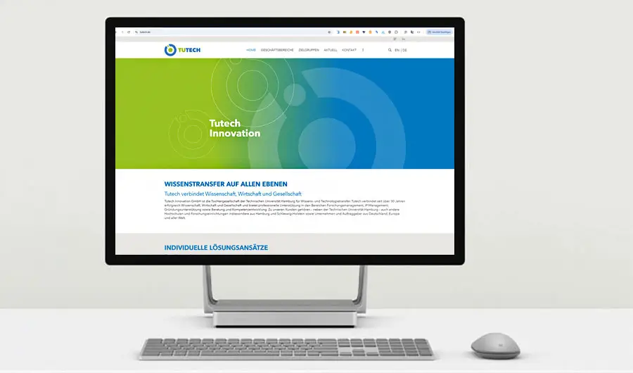 Computermonitor auf einem weißen Schreibtisch, auf dem die Website von Tutech Innovation zu sehen ist, die Webdesign in Harburg, Hamburg, präsentiert.